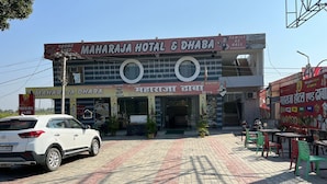 Um hotel com uma placa indicando "MAHARAJA HOTEL & DHABA".