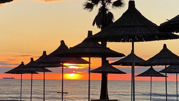 A beach with thatched umbrellas and a palm tree silhouetted against a sunset. - Bed&Breakfast by the sea 1 double room/2 persons (Kryevidh)