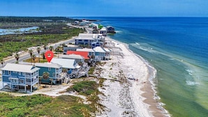 Una propiedad costera con varias construcciones, una playa y un muelle.