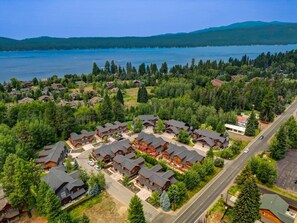 Ein Luftbild eines Wohngebiets mit Häusern, einer Straße und einem See im Hintergrund.