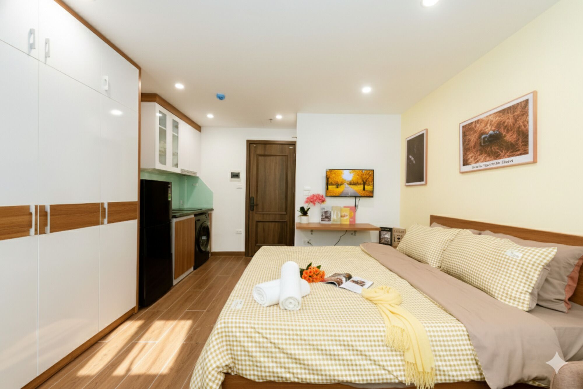 Een hotelkamer met een bed, een bureau met stoel, een kledingkast en een kitchenette.