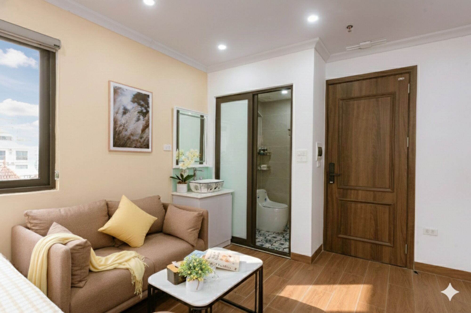 A living room with a sofa, a coffee table, and a door leading to a bathroom.