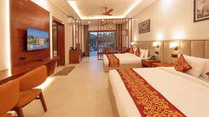 A hotel room with a TV, two beds, a desk, and a view of the outside. - The Corbett Sapphire (Kaladhungi)