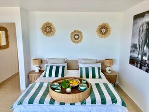 A neatly arranged bedroom with a bed centered on the wall, flanked by two nightstands. - Opale et Coralia : séjour de luxe en bord de mer (Oyster Pond)