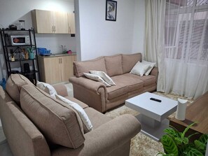 Departamento Deluxe, balcón, vista a la ciudad | Área de sala de estar | Smart TV