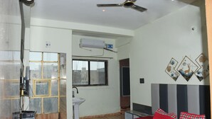 Una camera da letto con un letto, una ventola a soffitto, una finestra e un condizionatore d'aria a parete.