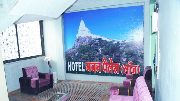 Una hall d'albergo con un grande murale raffigurante una montagna, una reception e diverse zone relax.