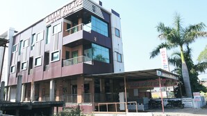 Un hotel a più piani con un'insegna che indica la presenza di camere e un ristorante.