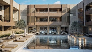 A modern building with a central courtyard, outdoor seating, and a pool. - Aethra Hotel & Suites (Nidri)