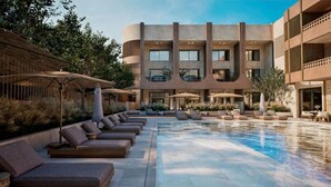 A modern hotel with a pool area, sun loungers, and outdoor seating. - Aethra Hotel & Suites (Nidri)