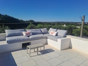 A sectional sofa with pillows, a bench, and a view of a landscape. - Lovely 4 bed 3 bathroom country house & pool Prime location near Ceglie & Ostuni (Ceglie Messapica)
