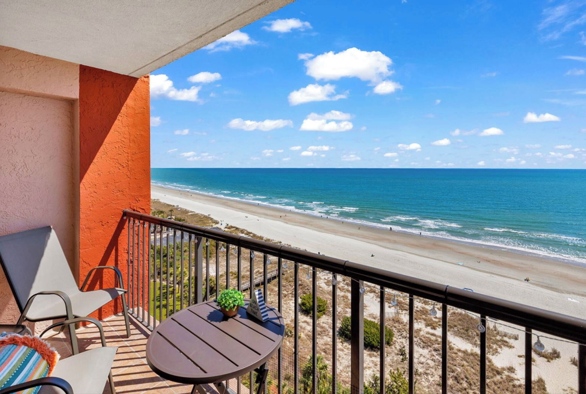Un balcon avec vue sur la plage et l’océan.