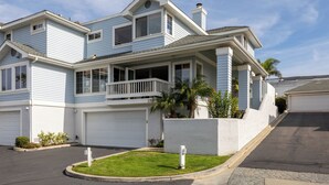 A two-story house with a garage, a covered porch, and a small garden. - Enchanting Ocean View Townhome | Walk to Beach, Dining & More (Encinitas)