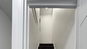 A staircase with dark carpeted steps leading to a landing. - Cardiff Central Gem - 2 Bed Apartment (Cardiff)