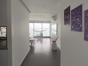 Et moderne hotelværelse med et stort vindue med havudsigt, en hængekøje og minimalistisk indretning.