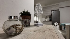 Eine Küche mit einer Holzarbeitsplatte, einem Blumentopf, einem Glasbehälter und einer modernen Lampe.