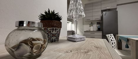 A kitchen with a wooden countertop, a potted plant, a glass jar, and a modern lamp.
