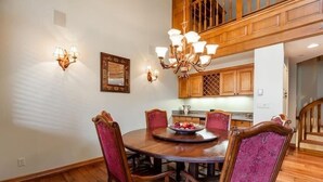 A dining room with a wooden table and chairs, a chandelier, and wall sconces. - Strawberry Park #604 5 Bedroom Condo (Avon)