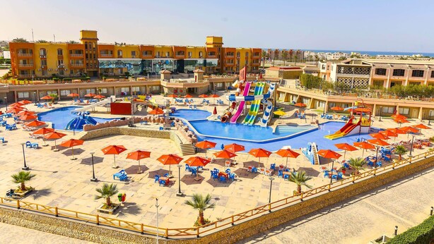 Un resort con varias piscinas, toboganes acuáticos y tumbonas.