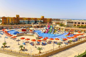 Een resort met diverse zwembaden, glijbanen en ligbedden.