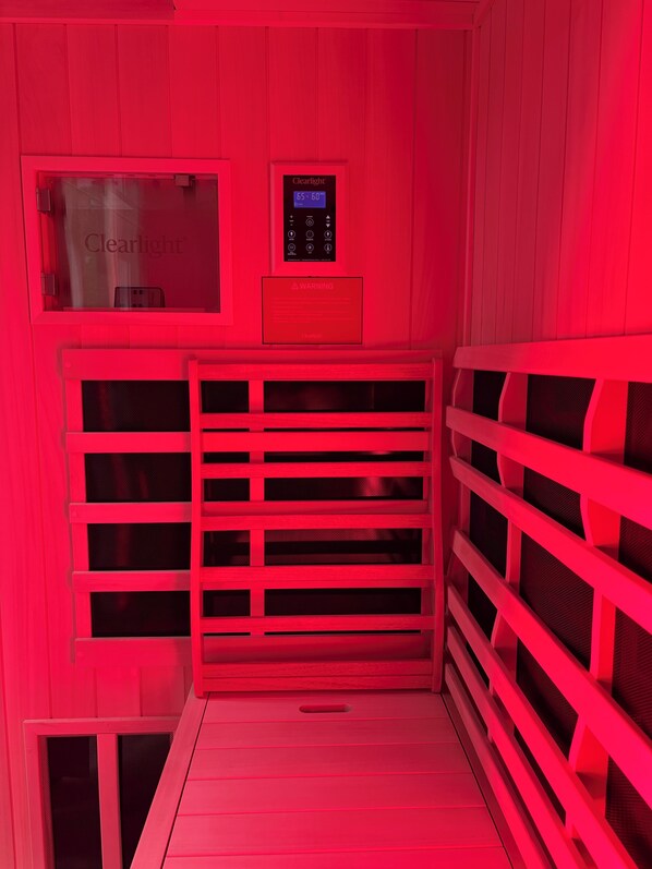 Eine Sauna mit Bedienfeld, das Temperatureinstellungen und ein Warnschild zeigt.