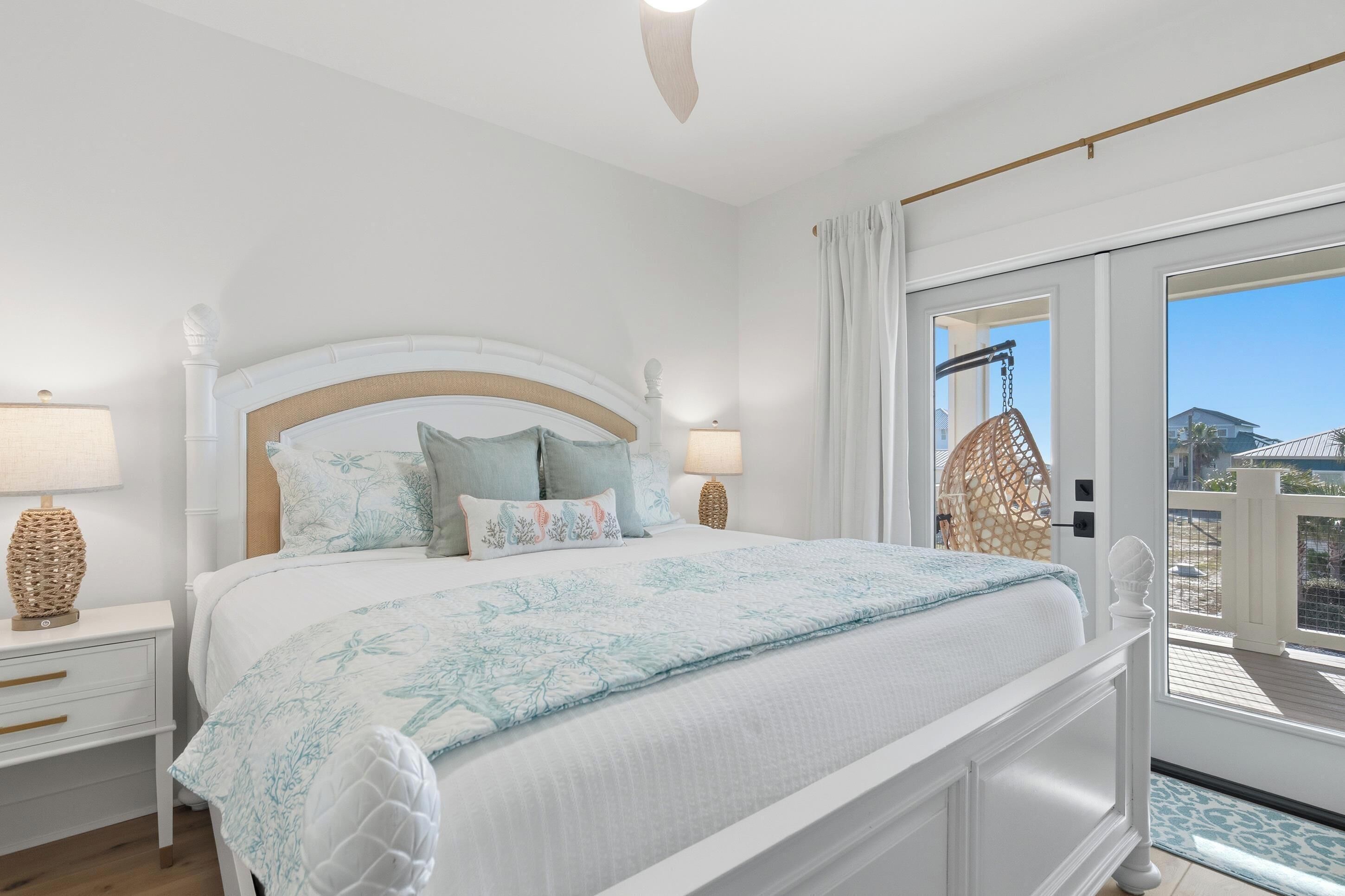Una camera da letto con un letto grande, due comodini con lampade e vista sul balcone esterno.