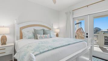 Una camera da letto con un letto grande, due comodini con lampade e vista sul balcone esterno.