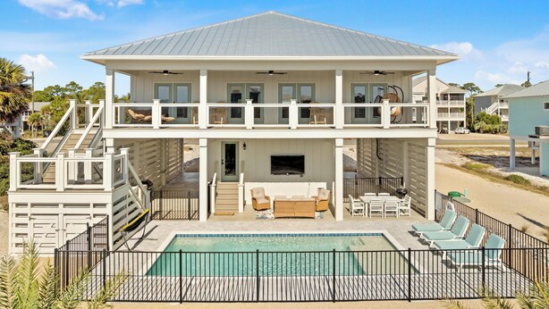 A two-story beachfront house with a pool, outdoor seating, and a covered patio. - Beach House - Walking on Water by PHG (St. George Island)