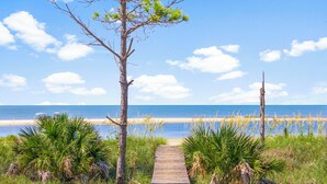 A wooden pathway leading to a beach with a clear view of the ocean. - Beach House - Walking on Water by PHG (St. George Island)
