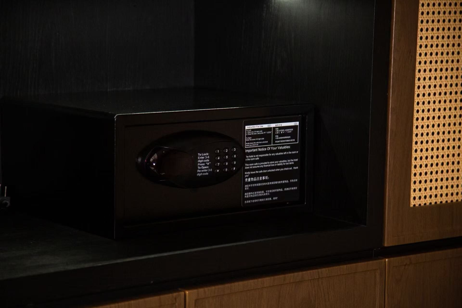 Una caja fuerte digital con instrucciones de uso y aviso sobre objetos de valor.