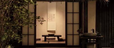 A traditional Japanese room with tatami flooring, a low table, and sliding doors.