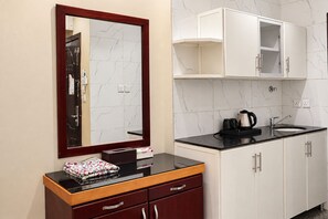 Een badkamer met een spiegel, een wastafel, een aanrecht en kastjes.