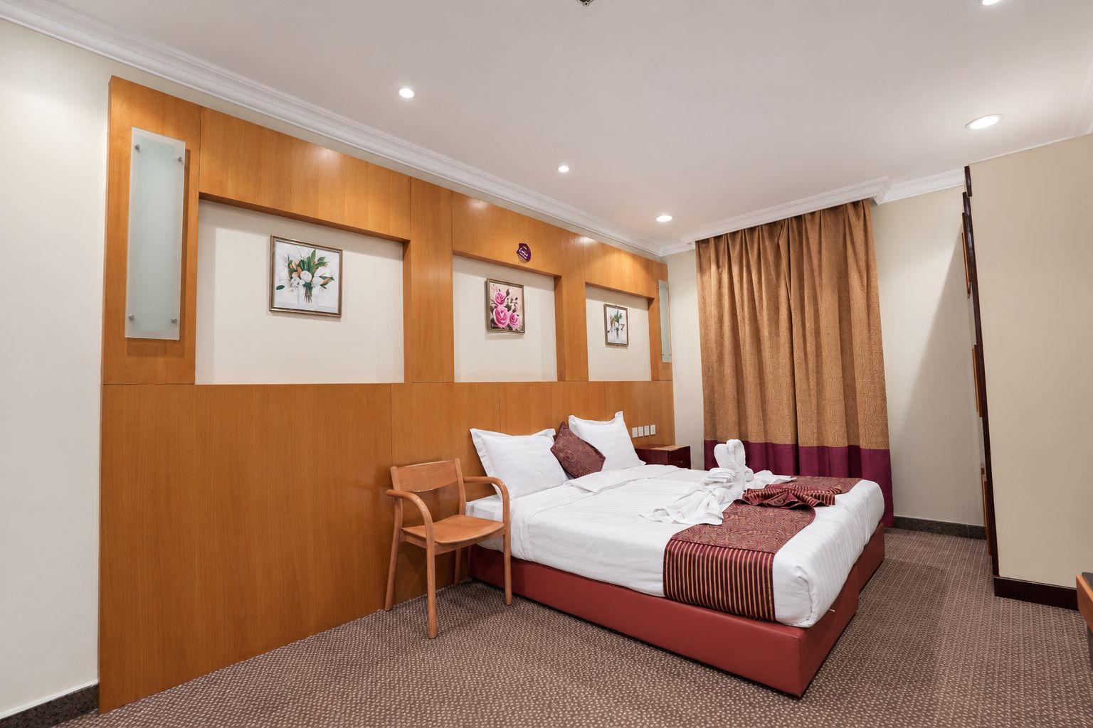 A hotel room with a bed, a chair, and a desk.