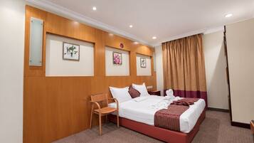 A hotel room with a bed, a chair, and a desk.
