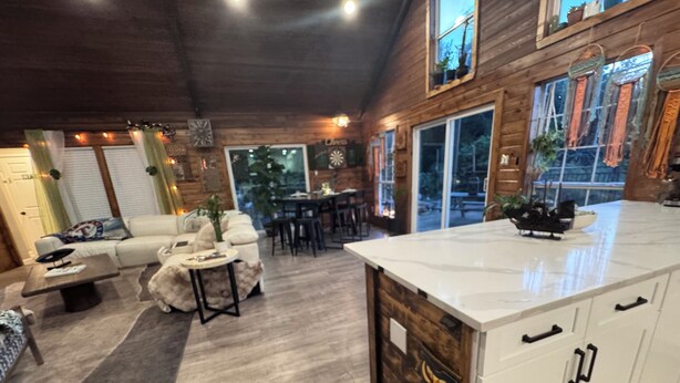 A spacious living area with a sofa, coffee table, and dining table. - Stunning and private lake front sunrise and sunset views! (Nevada)