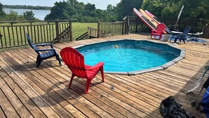A wooden deck with a swimming pool, surrounded by a wooden fence and chairs. - Stunning and private lake front sunrise and sunset views! (Nevada)