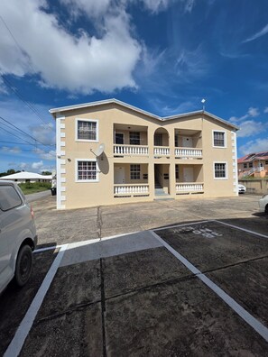 A two-story building with a symmetrical facade, multiple balconies, and a satellite dish. - Ajani - Cozy 2 Bedroom 1 Bath Apt next beach and activities, sleeps 4  (Oistins)