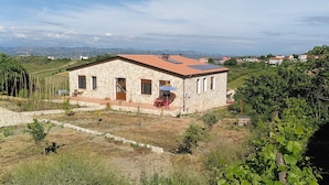 Une maison en pierre avec un toit en tuiles et un petit jardin.