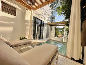 Ein Poolbereich mit Liege, kleinem Pool und einer Pergola.