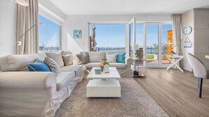 Ein modernes Wohnzimmer mit Sofa, Couchtisch und Blick auf die Stadt.