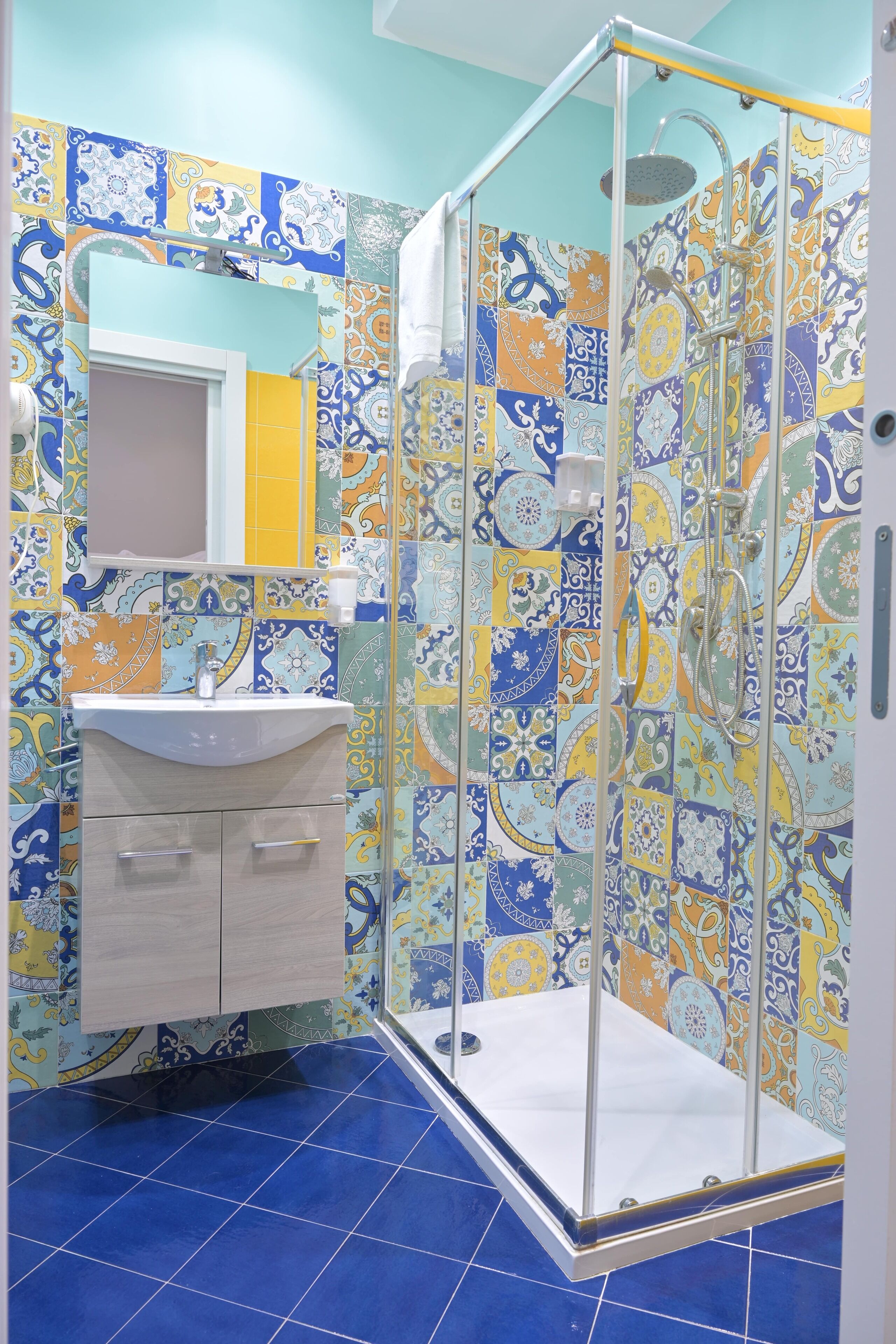A bathroom with a shower, sink, and tiled walls.