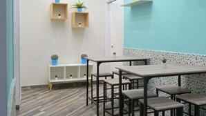 A modern interior with a teal accent wall, wooden flooring, and multiple seating areas. - La dimora del Sole (Ercolano)
