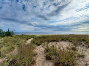 Une plage avec des dunes de sable et une végétation clairsemée.