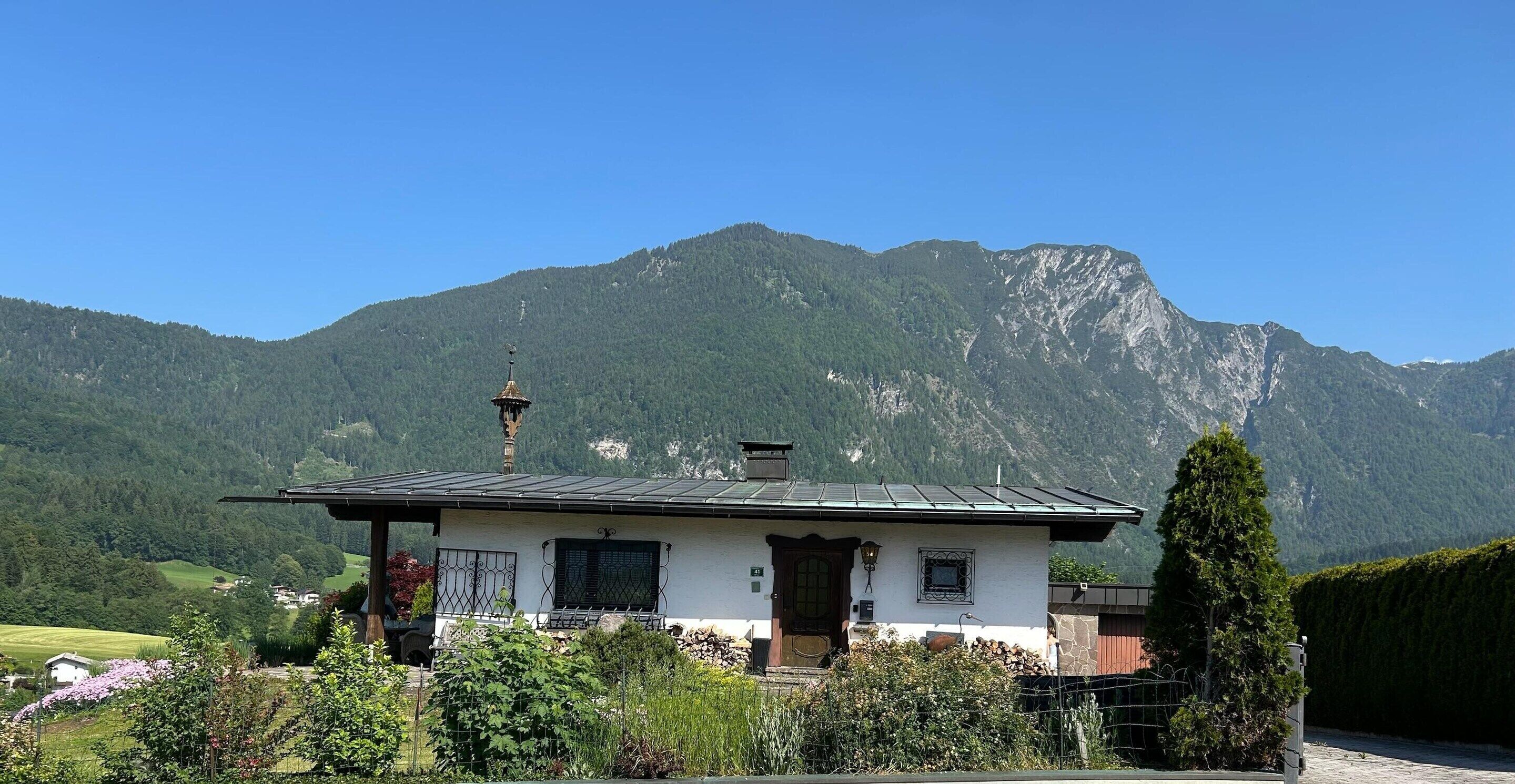 A mountain house with a sloped roof, a chimney, and a small porch.