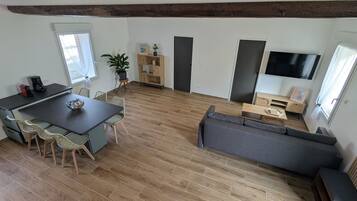 Ein moderner Wohnraum mit Küche, Essbereich und Sitzgelegenheit.