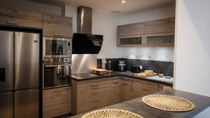Een moderne keuken met roestvrijstalen apparatuur, houten keukenkastjes en een ingebouwde magnetron.