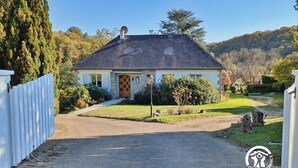 A house with a stone facade, a tiled roof, and a front door with a wooden panel. - Bright Gîte near Laval, 3 bedrooms, large grounds, ideal for families (L'Huisserie)