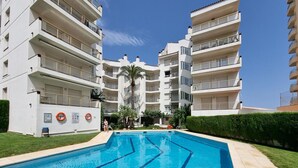 A modern apartment building with a swimming pool, multiple balconies, and a well-maintained garden. - Comfortable apartment with terrace 200m from the beach (L'Escala)