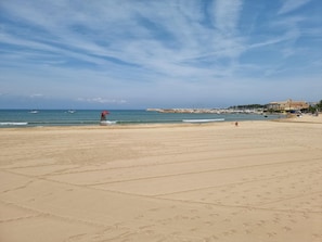 A wide sandy beach with a lifeguard tower and a clear blue sky. - Apartment in L'Escala with pool and parking, 600m from the beach (L'Escala)