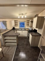 Una cocina compacta con una isla central, estufa y lavamanos.